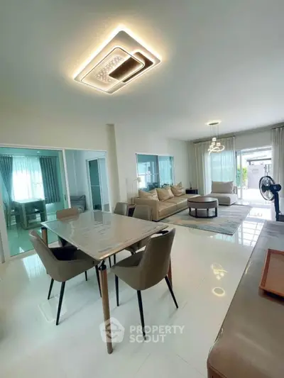 Modern open-plan living and dining area with stylish lighting and elegant furnishings.