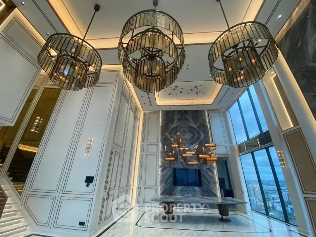Luxurious high-ceiling lobby with elegant chandeliers and panoramic city view.