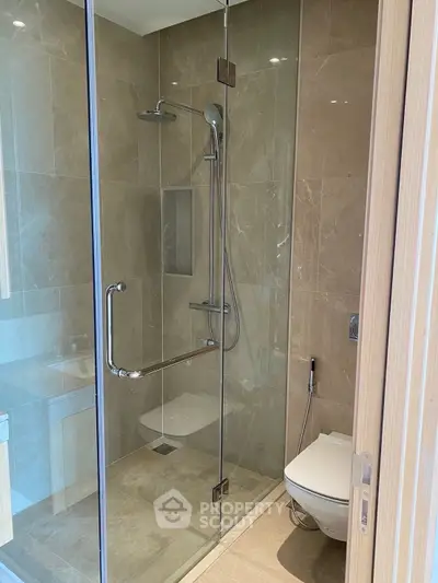 Modern bathroom with glass shower enclosure and sleek fixtures