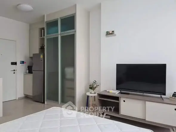 Modern living room with TV and sleek furniture in a cozy apartment setting.