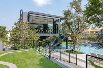 Modern gym with glass walls overlooking a luxurious pool and landscaped garden.