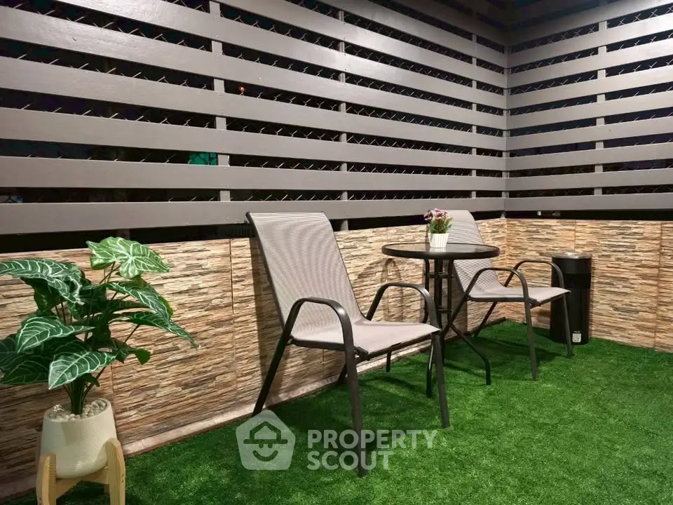 Charming outdoor patio with cozy seating and lush greenery, perfect for relaxation and entertaining.