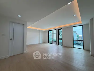 Spacious modern living room with large windows and wooden flooring