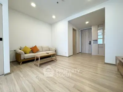 Spacious modern living room with wooden flooring and cozy sofa in a stylish apartment.