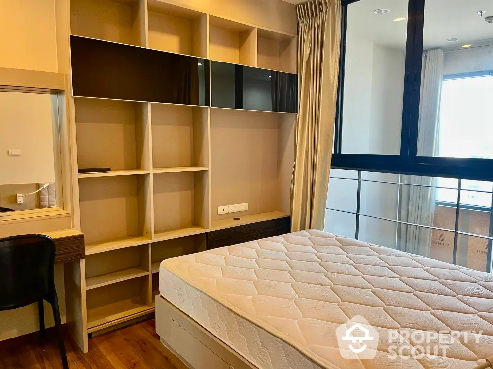 Modern bedroom with built-in shelving and large window for natural light