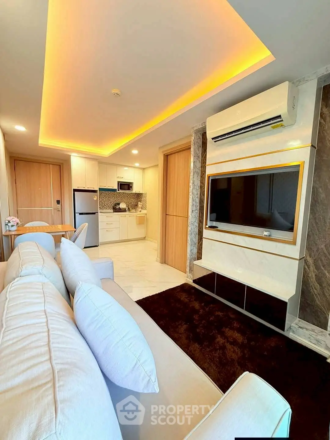 Modern living room with stylish lighting and open kitchen layout in luxury apartment.