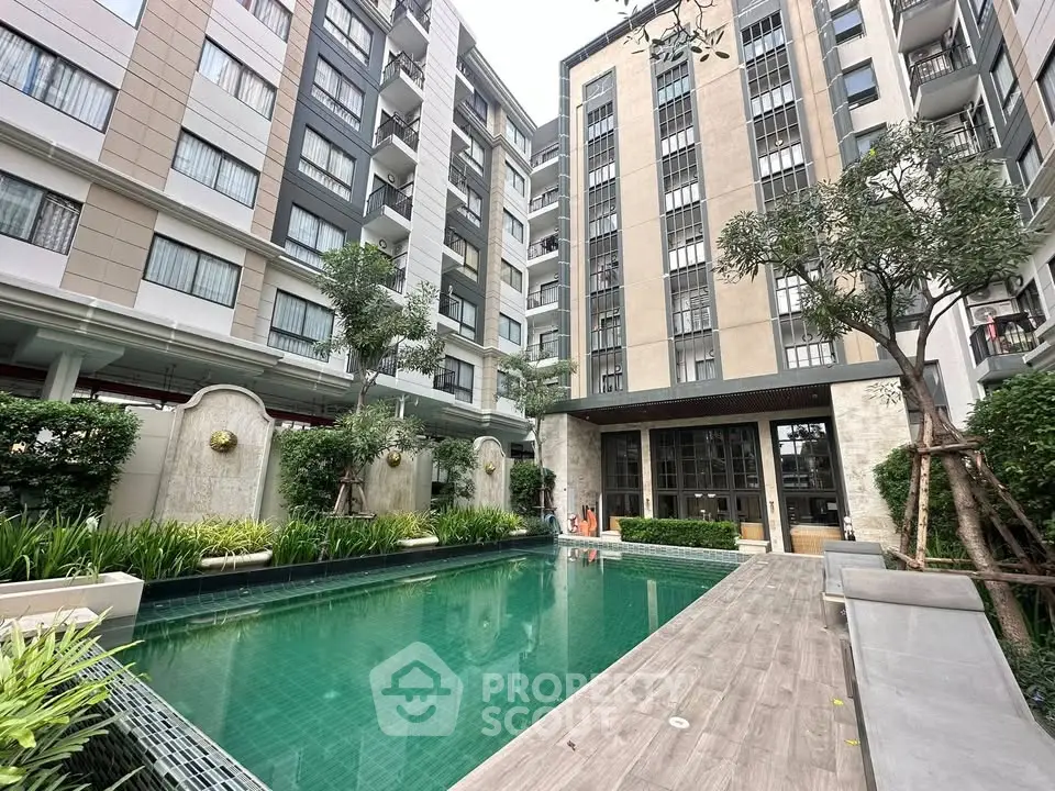 Modern apartment complex with a stylish pool and lush greenery, offering a serene urban living experience.