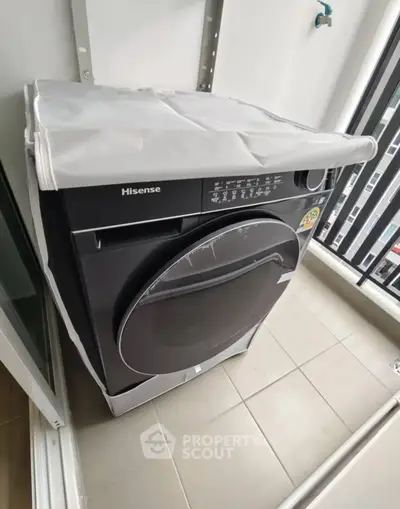 Modern Hisense washing machine on a balcony with sleek design and city view.