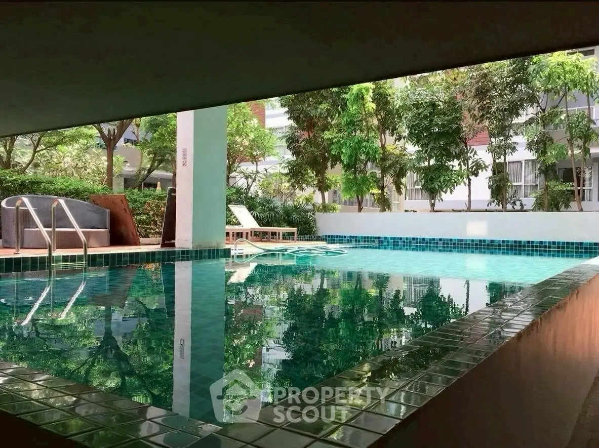 Luxurious poolside view with lush greenery in modern residential complex