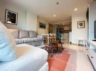 Spacious living room with cozy seating and modern decor in open layout apartment.