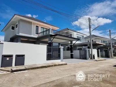 Modern two-story house with sleek design and spacious driveway in a suburban neighborhood.