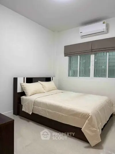 Cozy bedroom with modern air conditioning and elegant bedding in a serene setting.