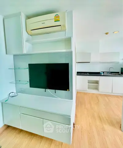 Modern apartment interior with sleek kitchen and built-in entertainment unit