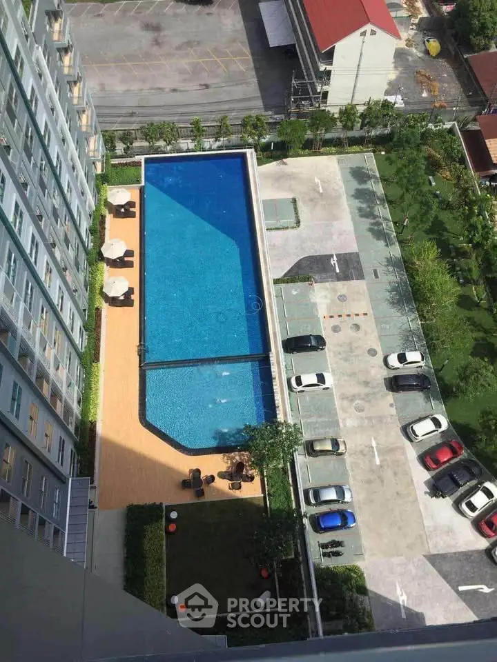 Stunning aerial view of modern apartment complex with pool and parking area.
