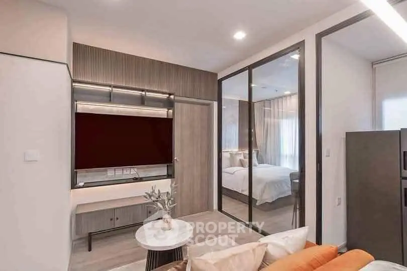 Modern living room with stylish decor and view into cozy bedroom