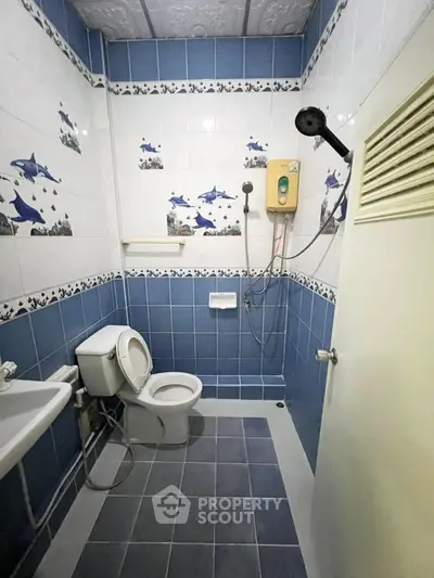 Charming bathroom with ocean-themed tiles and modern shower in cozy real estate property.