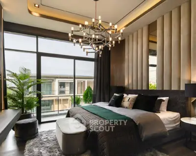 Luxurious modern bedroom with elegant chandelier and large windows offering stunning views.