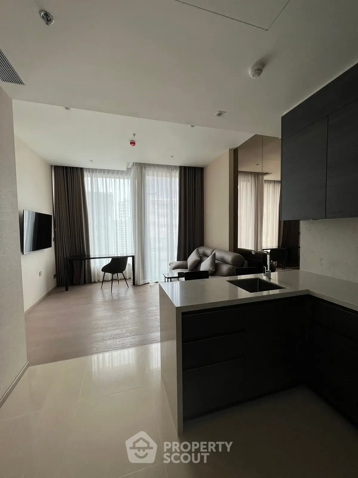 Modern open-plan living room with sleek kitchen and large windows