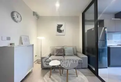 Modern living room with cozy sofa and stylish kitchen in open layout apartment.