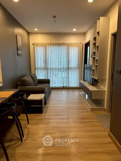 Modern living room with sleek furniture and large window, perfect for cozy urban living.