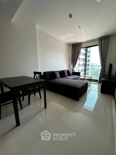 Modern living room with sleek furniture and city view from large window.