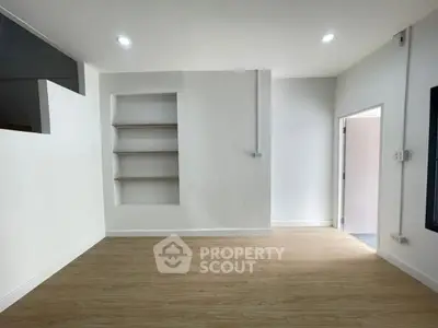 Spacious modern living room with built-in shelves and wooden flooring