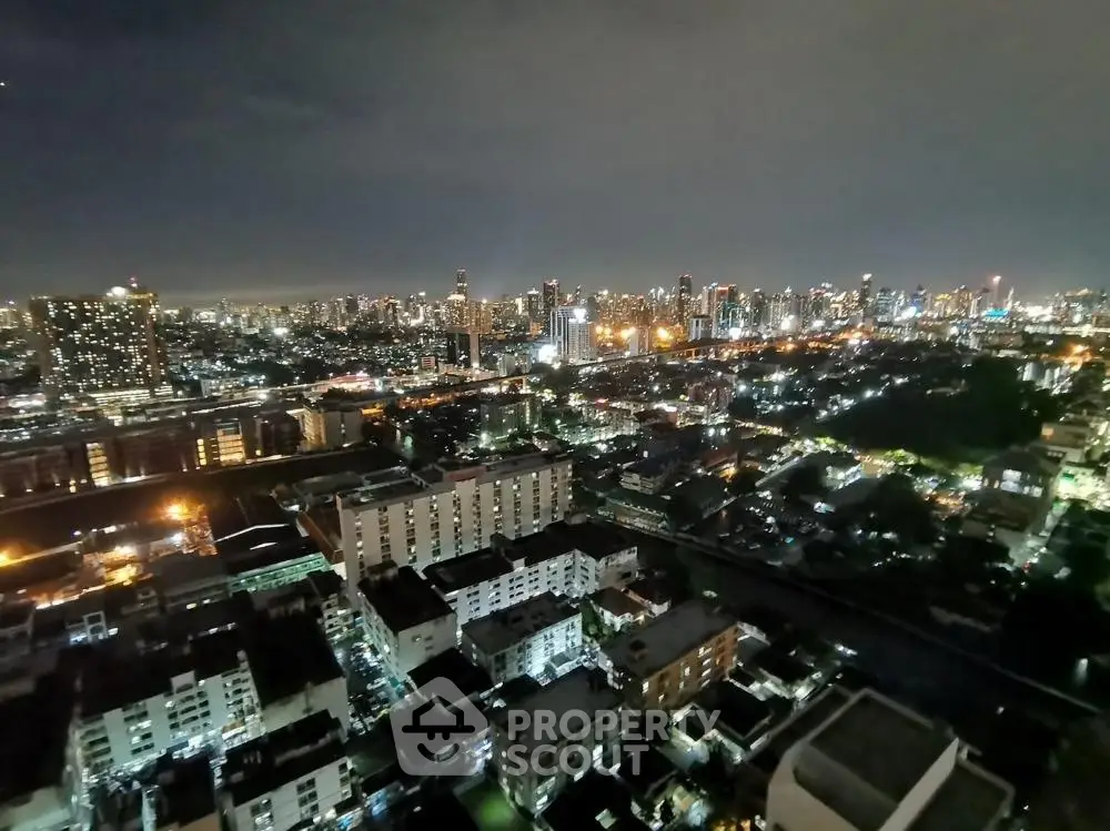 Stunning cityscape view from high-rise apartment at night, showcasing vibrant urban lights.