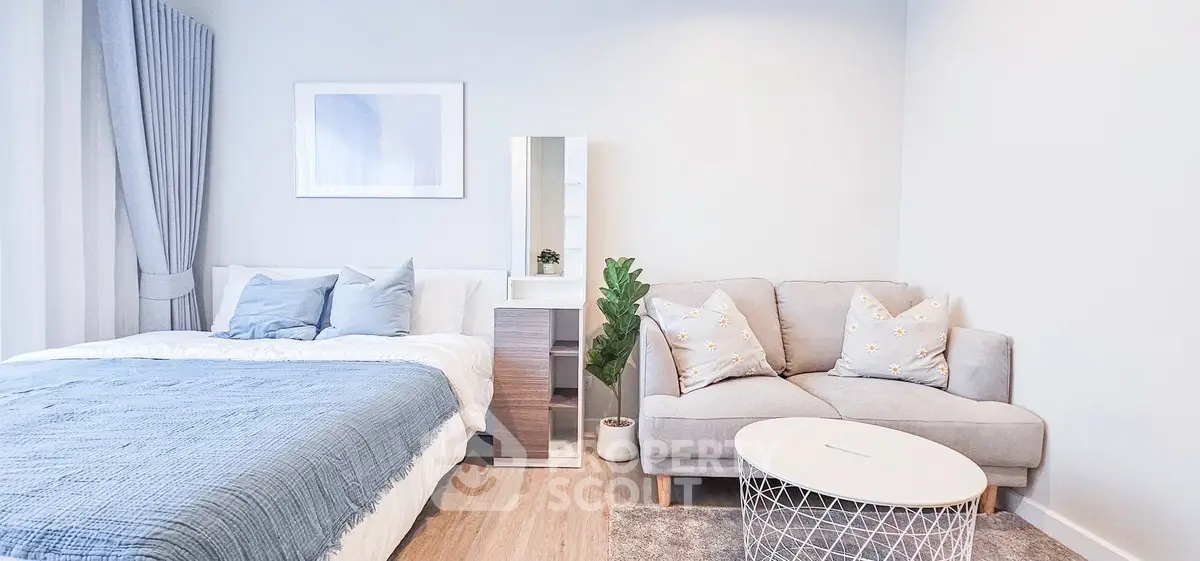 Modern bedroom with cozy bed, stylish sofa, and elegant decor in a bright, inviting space.
