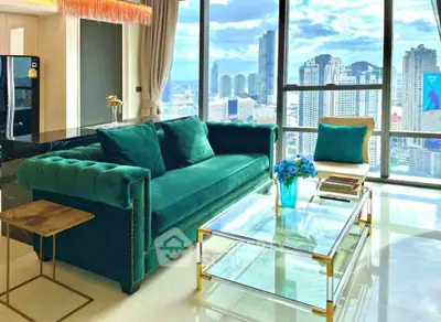 Luxurious living room with stunning city view, elegant green sofa, and modern glass coffee table.