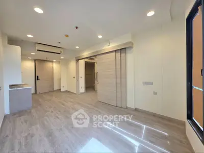 Modern open-plan living space with sleek flooring and recessed lighting