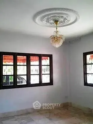 Elegant empty room with chandelier and large windows, perfect for customization.