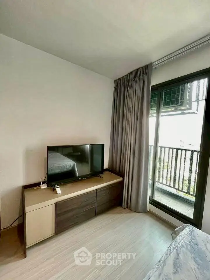 Modern bedroom with TV and balcony view, perfect for urban living.