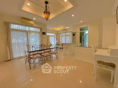 Spacious open-layout living and dining area with elegant lighting and large windows.