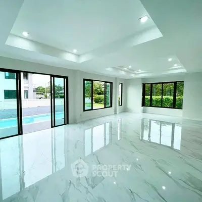Spacious modern living room with large windows and pool view