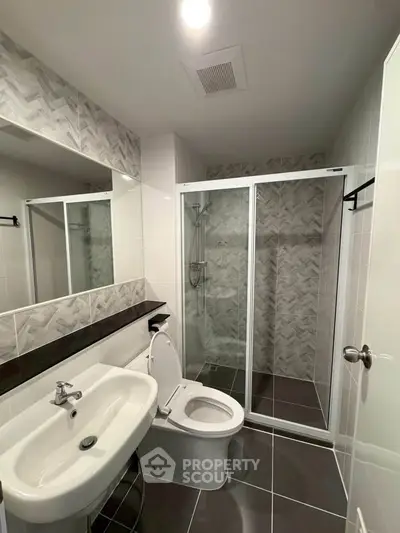 Modern bathroom with sleek shower enclosure and stylish tile design.