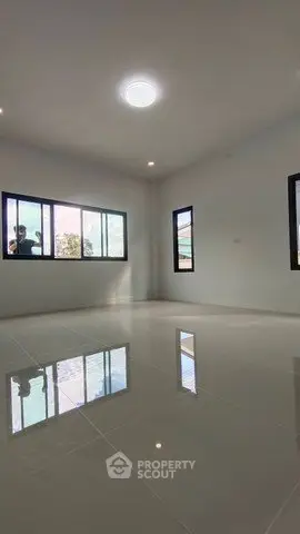 Spacious empty room with large windows and glossy tiled floor