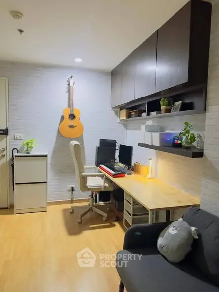 Cozy study room with modern desk, chair, and wall-mounted guitar in stylish apartment.