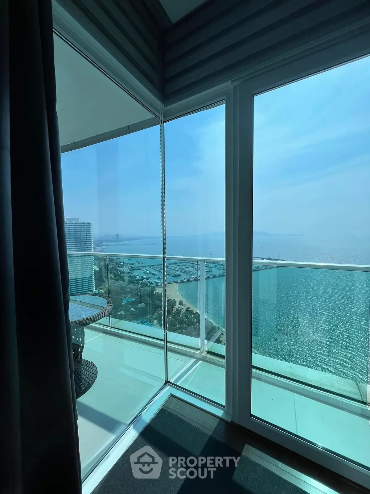 Stunning ocean view from high-rise balcony with glass railing and modern design.