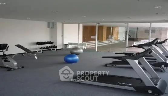 Modern gym with treadmills and weights in a sleek residential building.