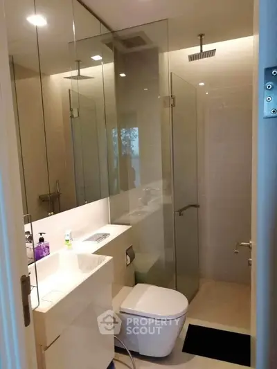 Modern bathroom with glass shower enclosure and sleek fixtures