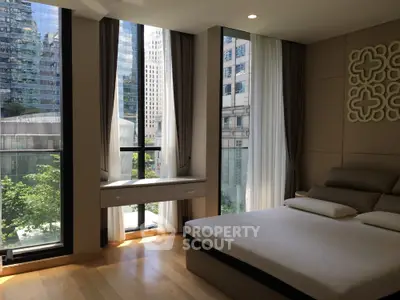 Luxurious bedroom with floor-to-ceiling windows offering stunning city views in a modern high-rise building.