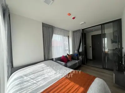 Modern bedroom with large windows, cozy bed, and stylish decor in a bright apartment.