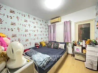Cozy bedroom with playful wallpaper and ample natural light