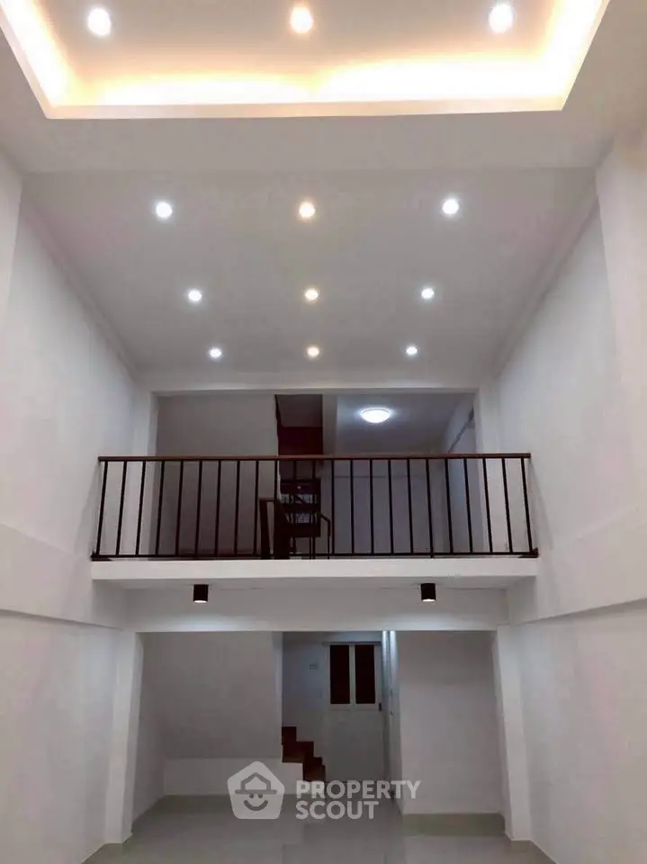 Spacious modern interior with high ceiling and mezzanine level, perfect for stylish living.