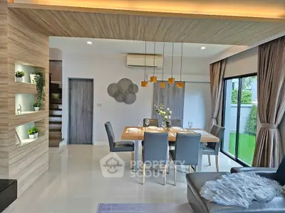 Modern dining area with elegant decor and garden view, featuring stylish lighting and cozy seating.
