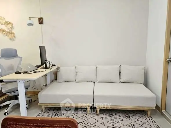 Modern study room with ergonomic chair, adjustable desk, and cozy sofa.