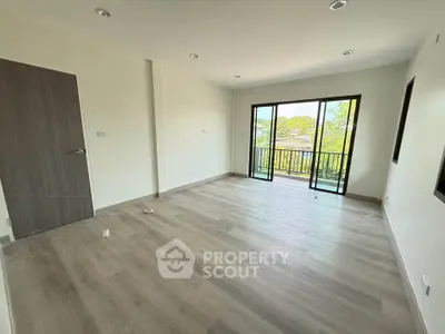 Spacious empty room with large windows and balcony view, perfect for customization.