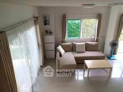 Spacious living room with modern beige sofa and large windows for natural light