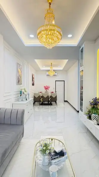 Luxurious living room with elegant chandelier and modern dining area
