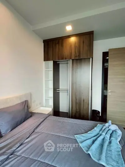 Modern bedroom with sleek wardrobe and cozy bedding in a stylish apartment.